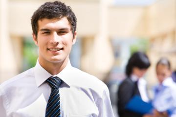 A person in business attire with people in the background.