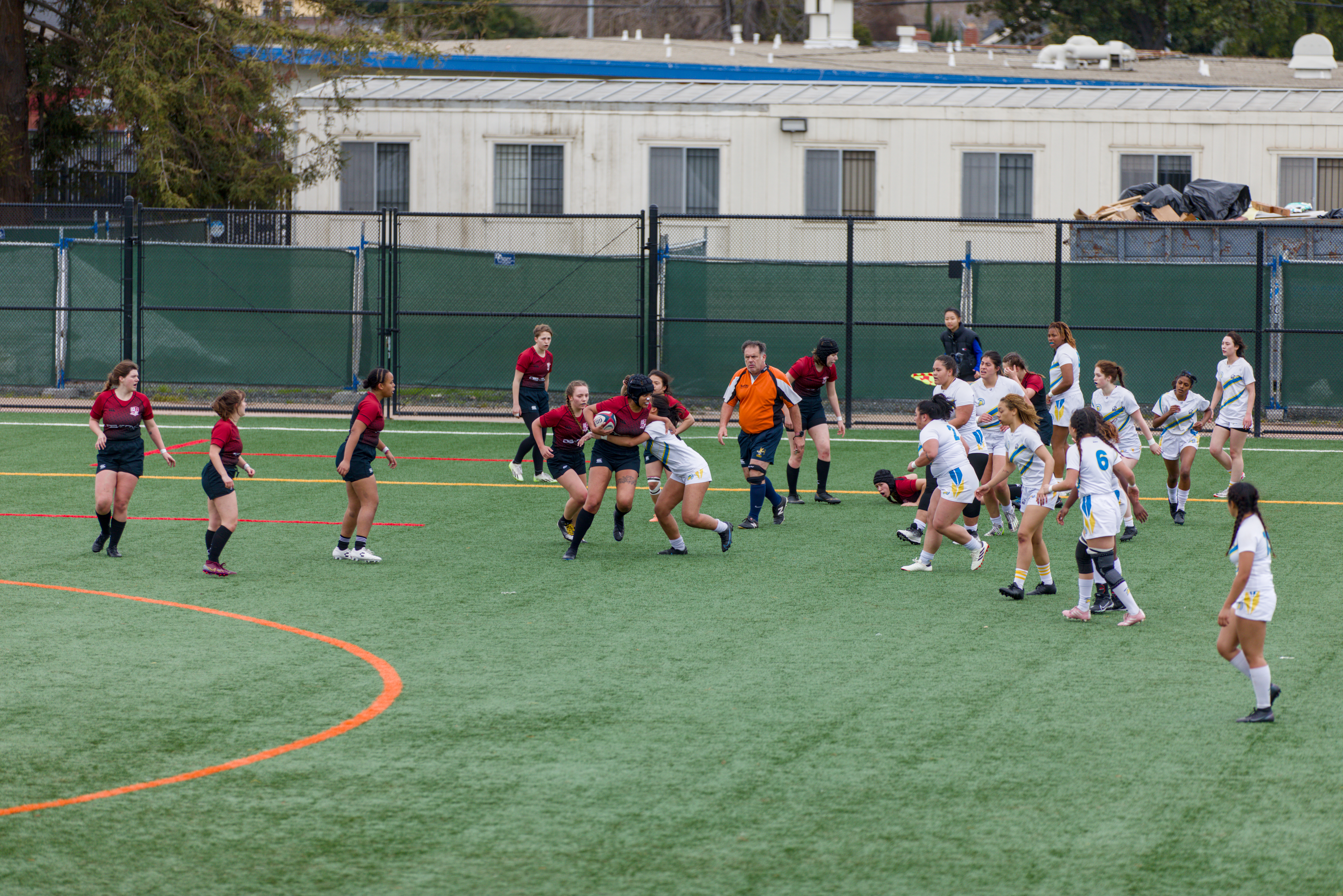 Women's Rugby Team competing driving the ball down field